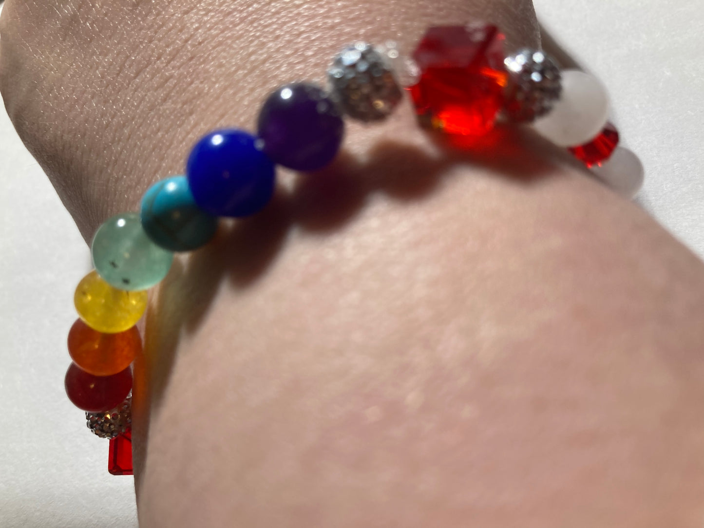 White Quartz, Crystal Siam corner cut cubes, and Chakra gemstones with a dainty Tibetan silver fairy dangling.