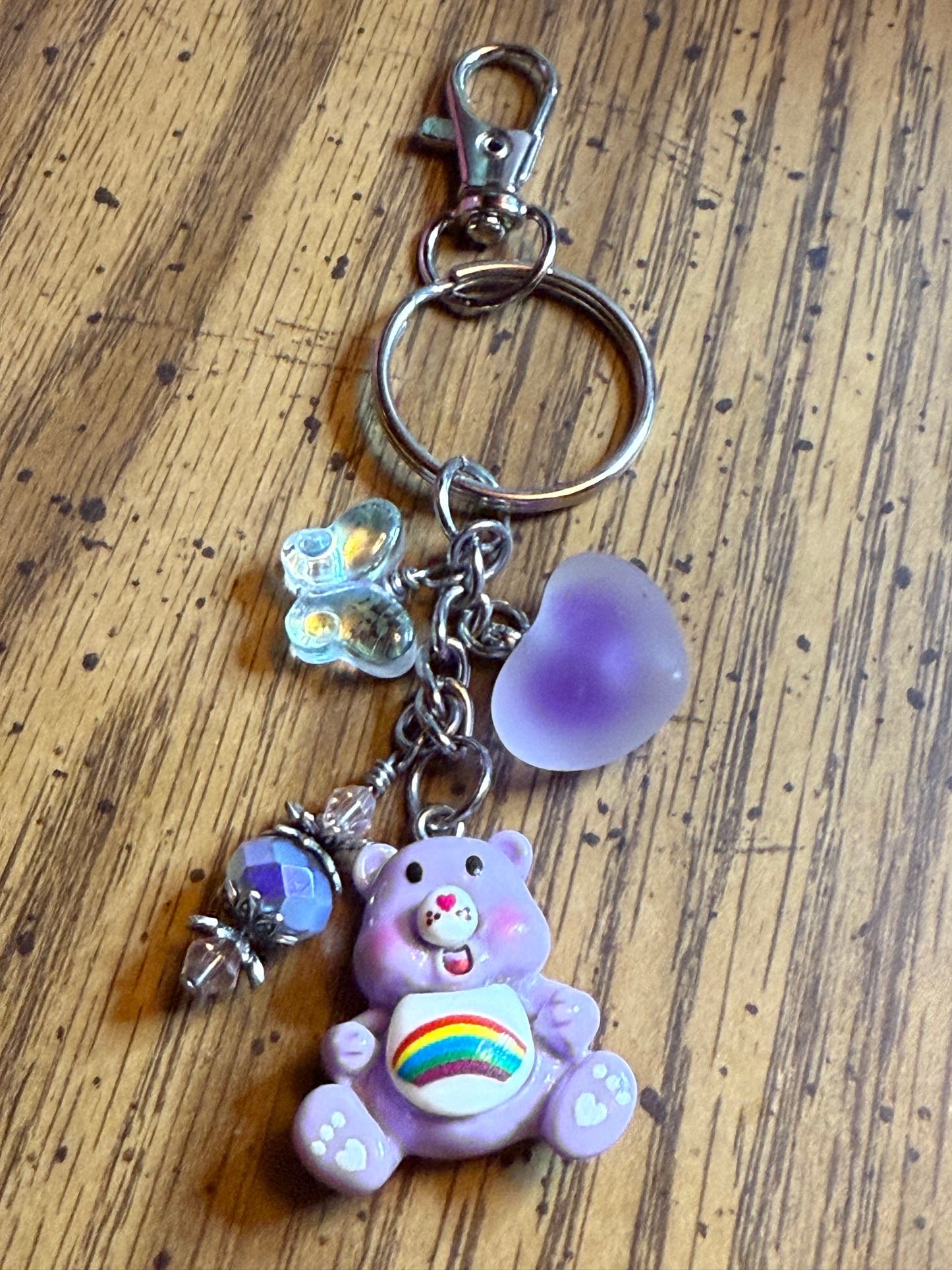 Purple Bear with Rainbow on belly Key Chain with crystal butterfly, and Acrylic purple puffy heart.
