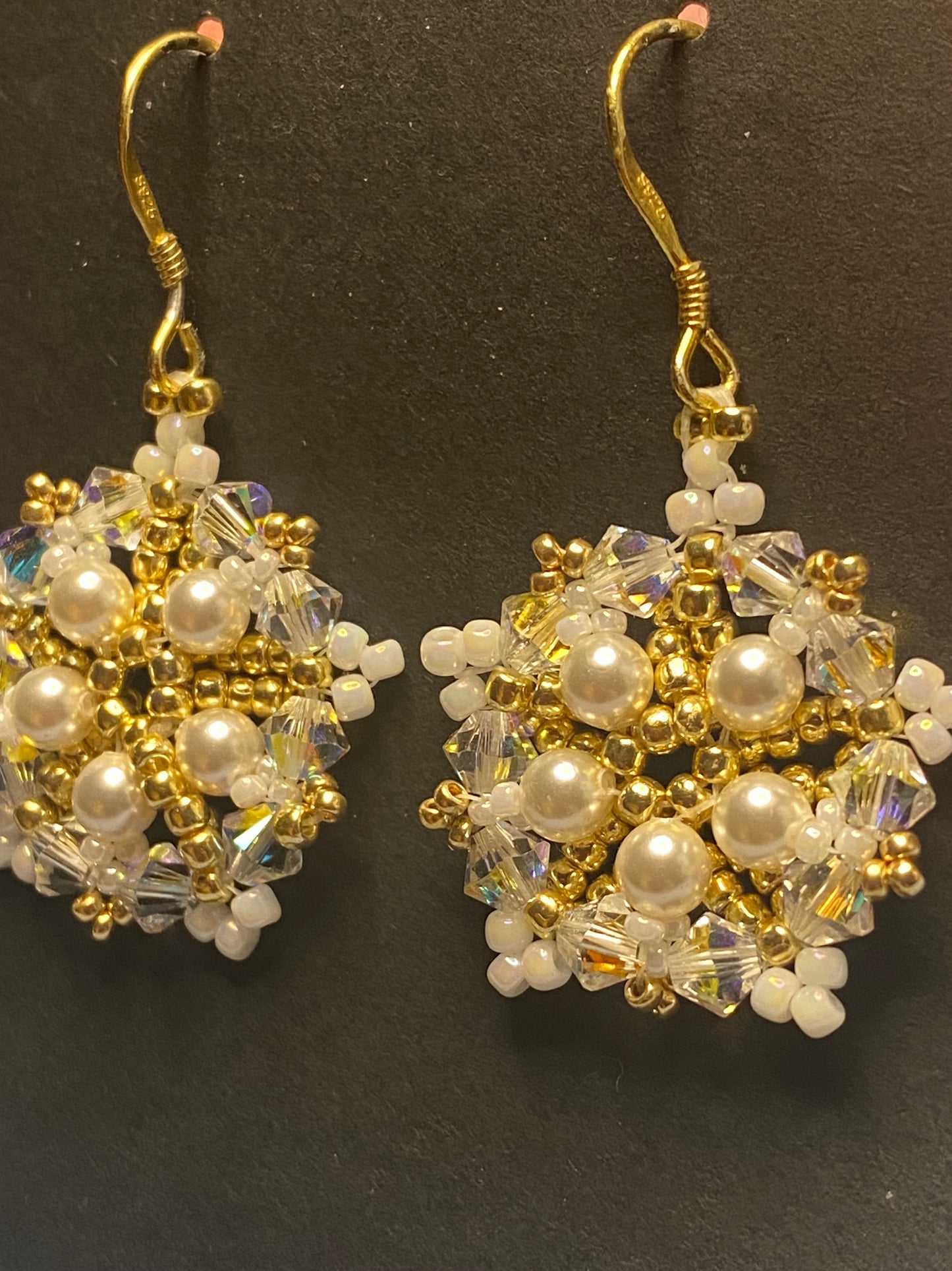 White Snowflake earrings feature shimmering Swarovski pearls and crystals. Elevate any outfit with the delicate touch of gold and sparkle.