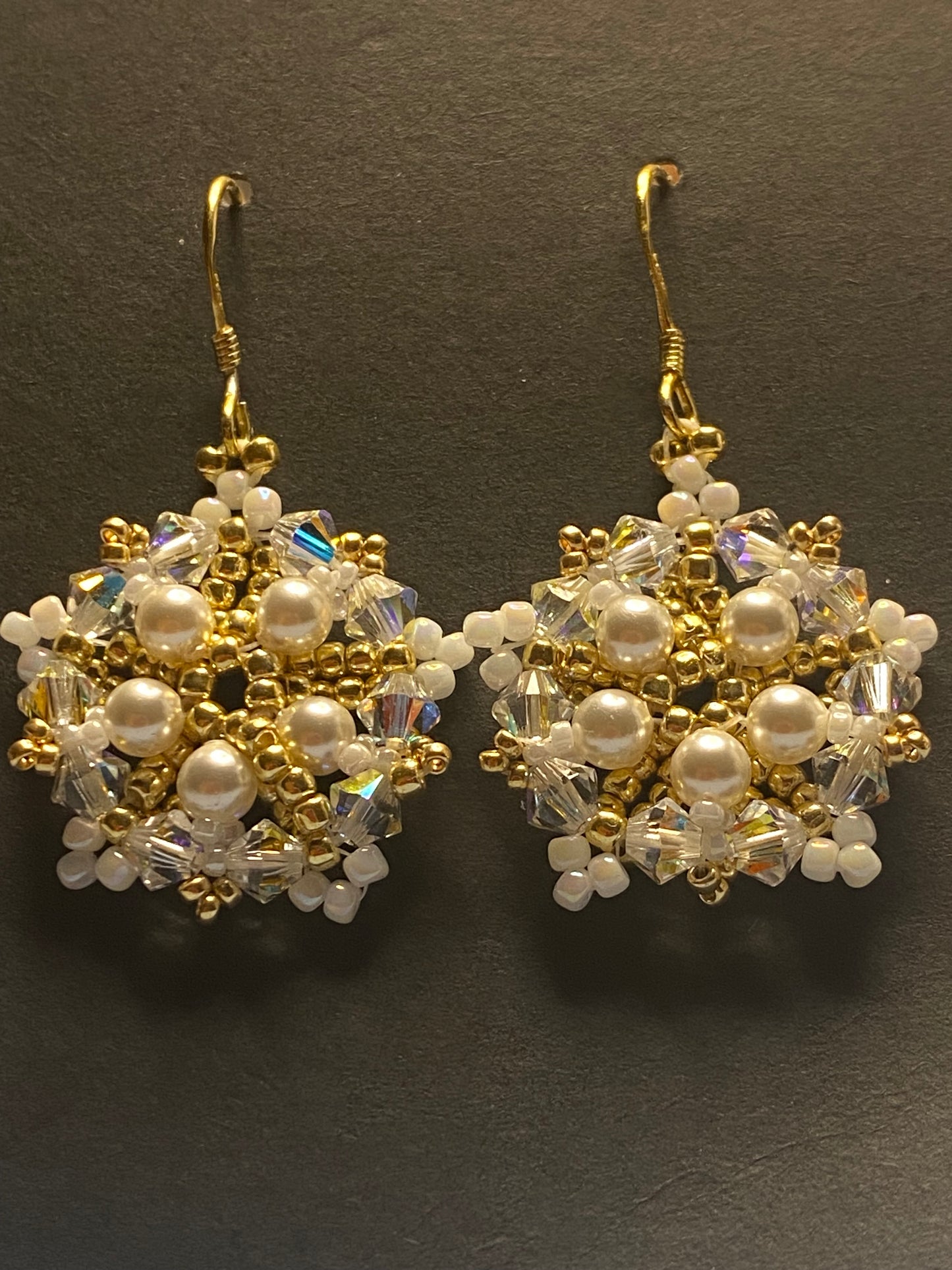 White Snowflake earrings feature shimmering Swarovski pearls and crystals. Elevate any outfit with the delicate touch of gold and sparkle.