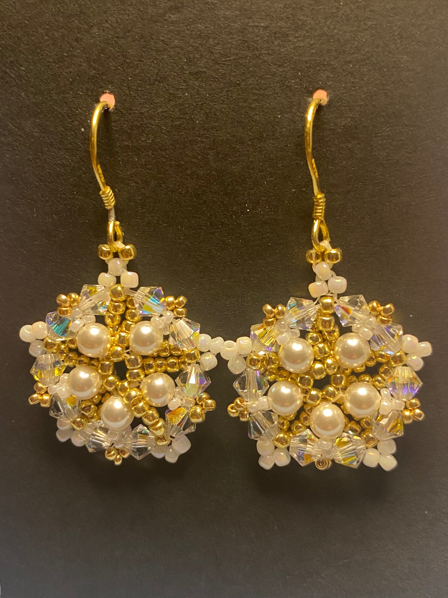 White Snowflake earrings feature shimmering Swarovski pearls and crystals. Elevate any outfit with the delicate touch of gold and sparkle.