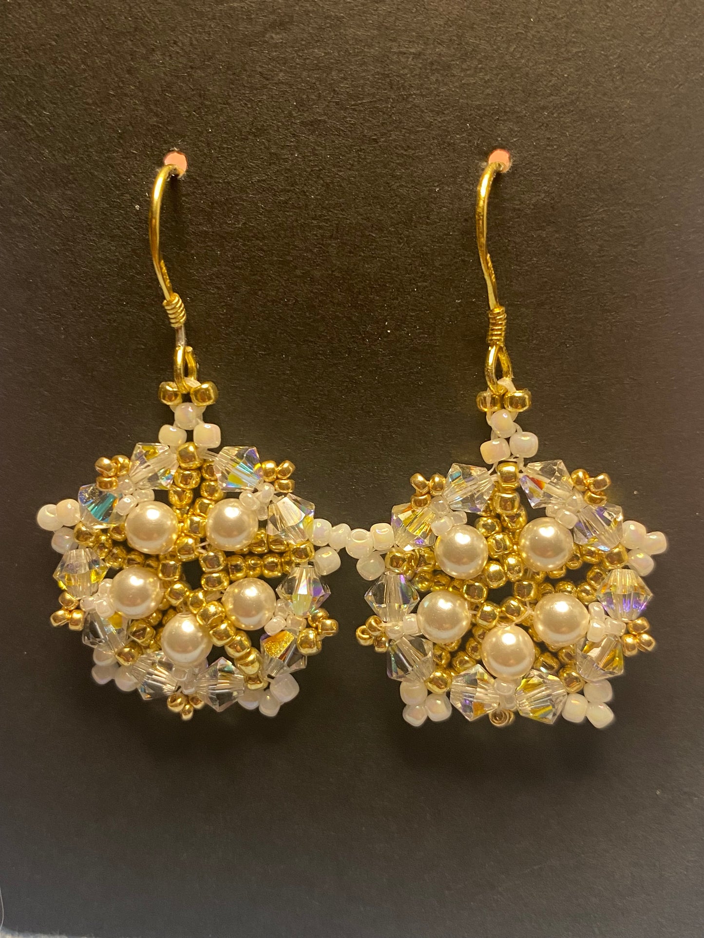 White Snowflake earrings feature shimmering Swarovski pearls and crystals. Elevate any outfit with the delicate touch of gold and sparkle.